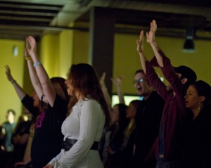 Worshipers singing and lifting hands at Sojourn Community Church's Midtown Campus. Photo taken by Chuck Heeke