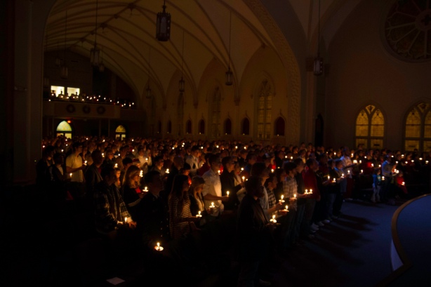 Sojourn Church worshipers holding candles in the darkened St. Vincent's cathedrals